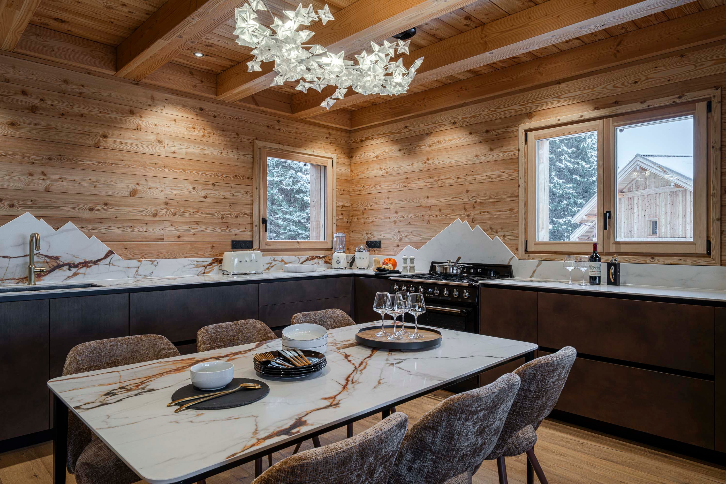 Cuisine avec crédence en marbre Calacatta découpée en silhouette de montagnes et piano de cuisson Smeg