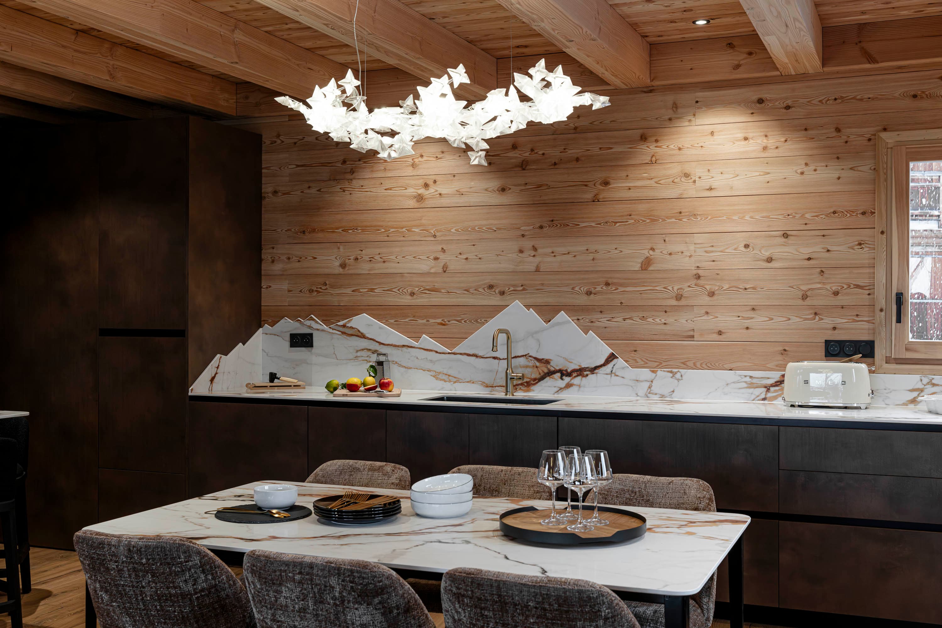 Détail du piano de cuisson Smeg et de la crédence en marbre découpée en montagnes