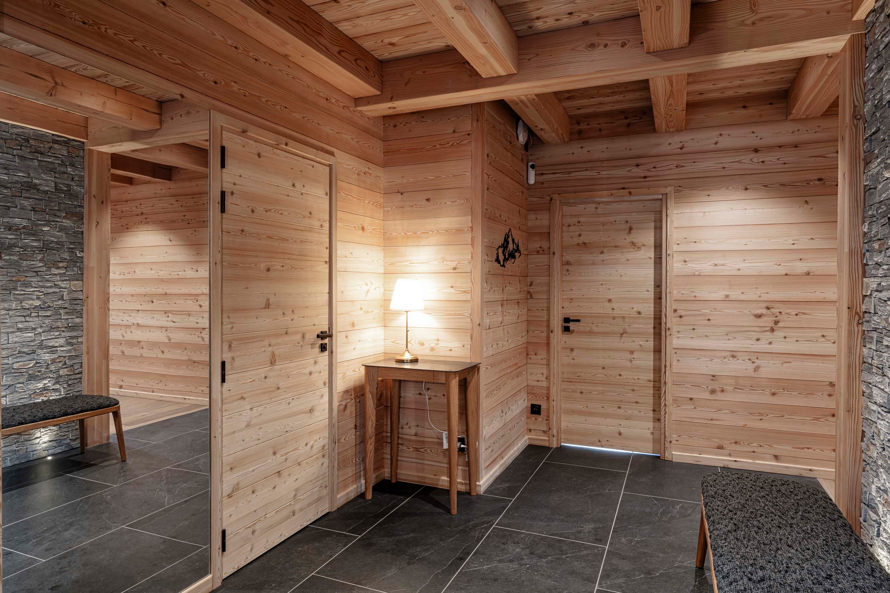 Couloir d'entrée avec portes en bois, console et lampe d'appoint