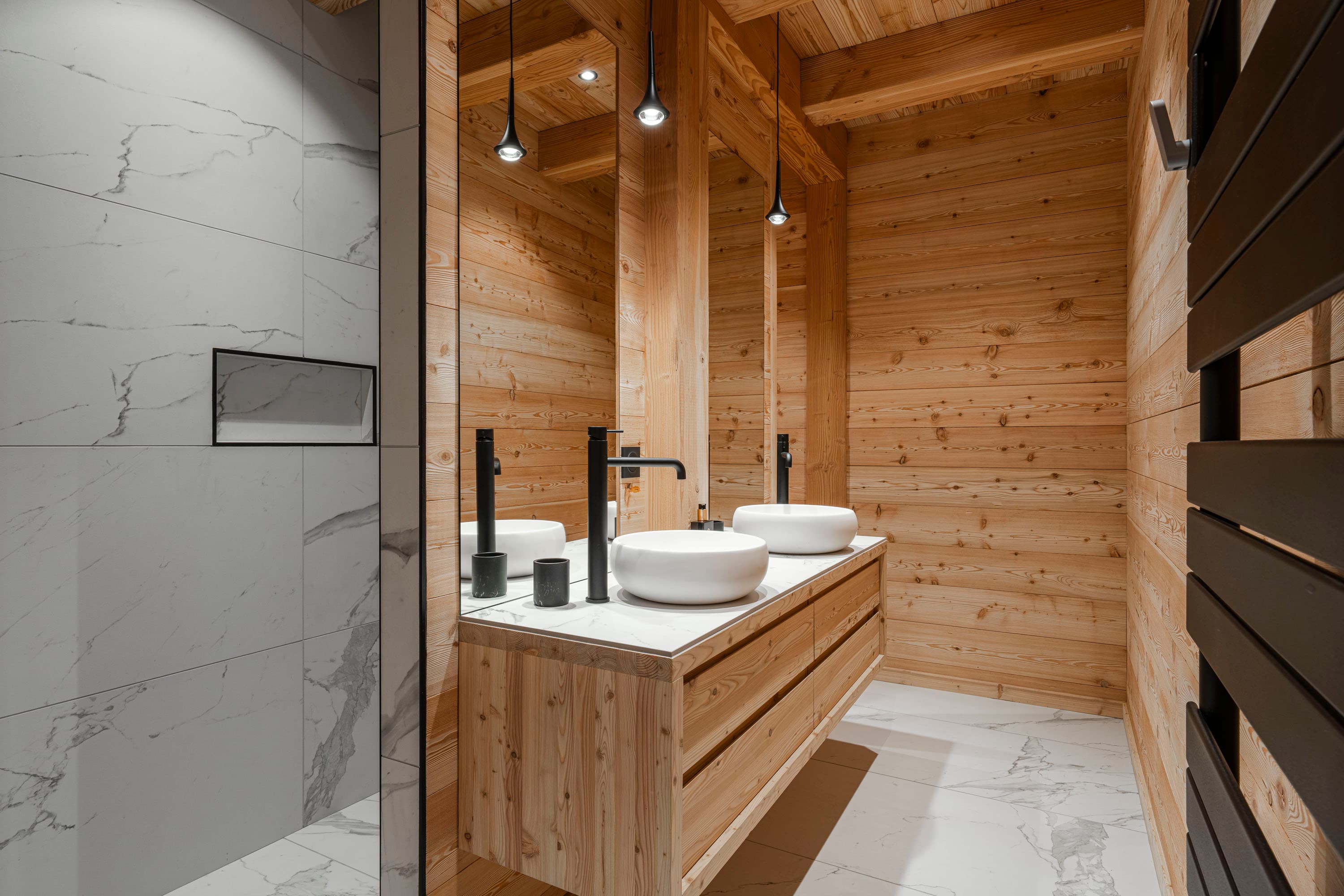Salle d'eau avec double vasque en céramique, meuble en bois et carrelage blanc marbré