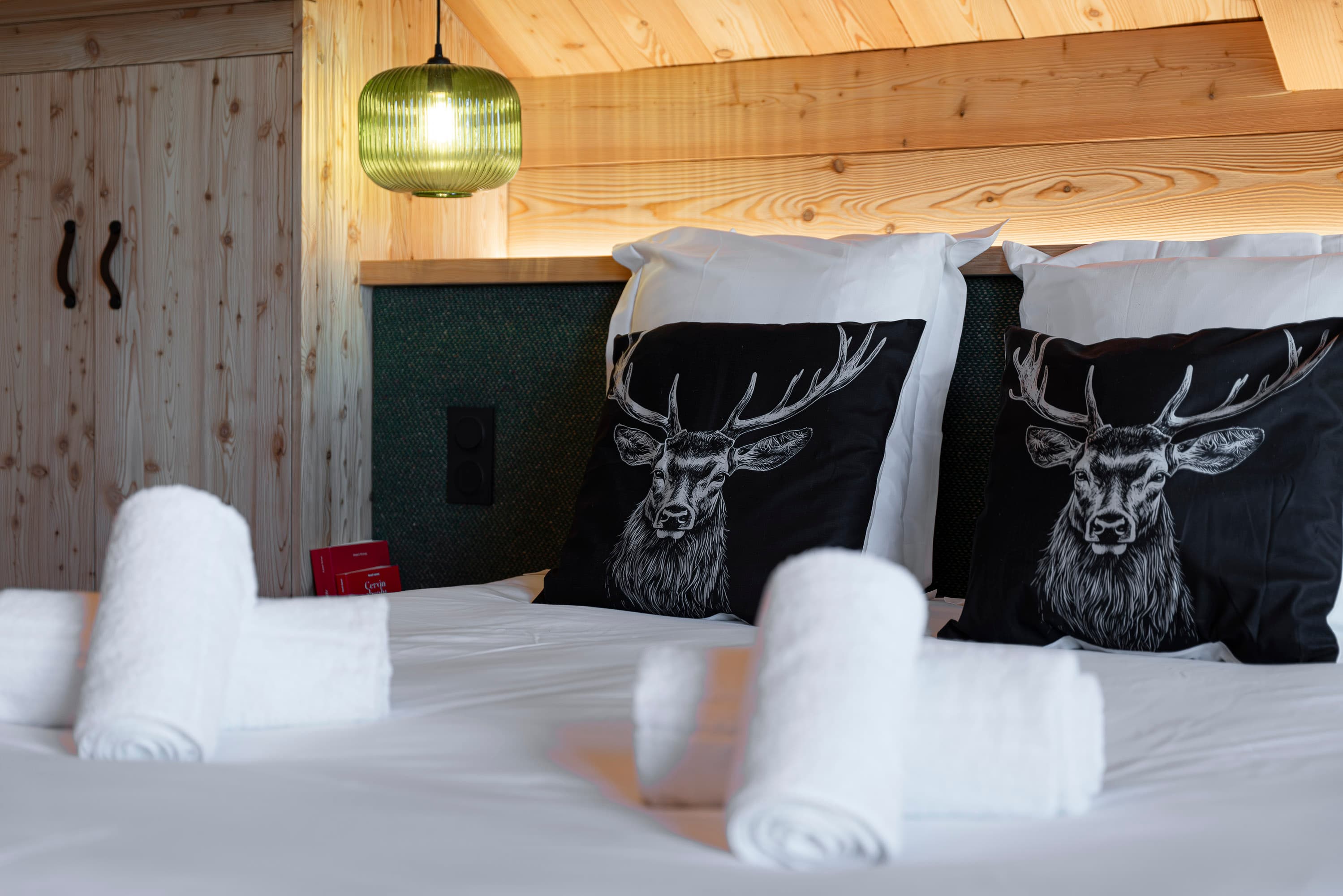 Détail des coussins noirs motif cerf avec suspensions vertes