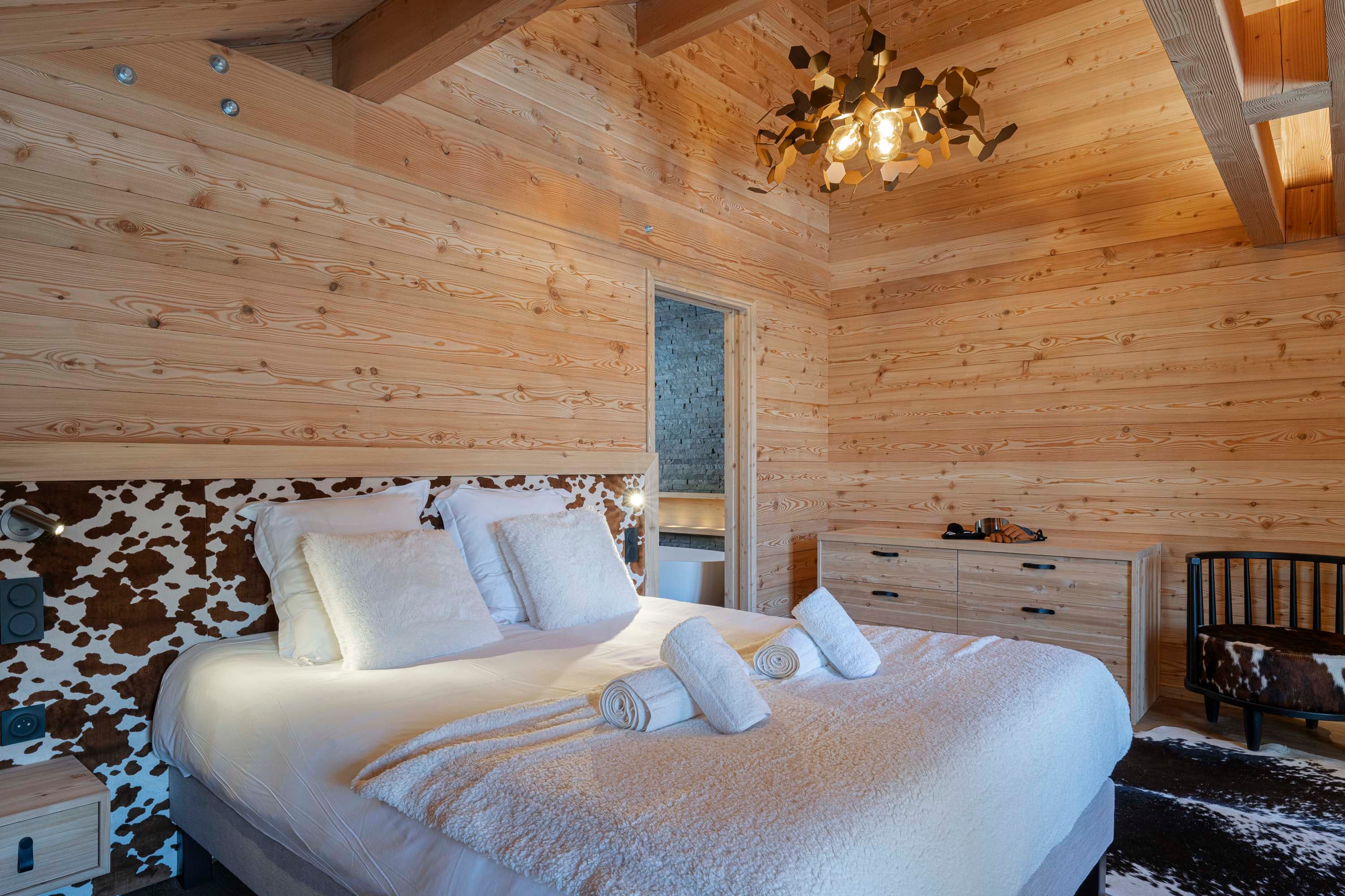 Lit king size avec coussins, serviettes roulées et suspension dorée hexagonale